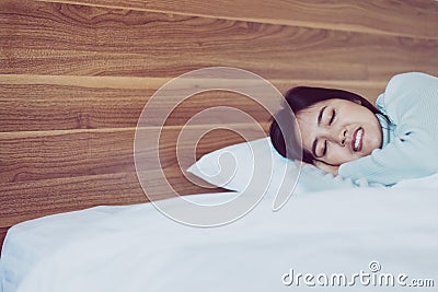 Young asian woman sleeping on bedroom and grinding teeth,Female tiredness and stress Stock Photo