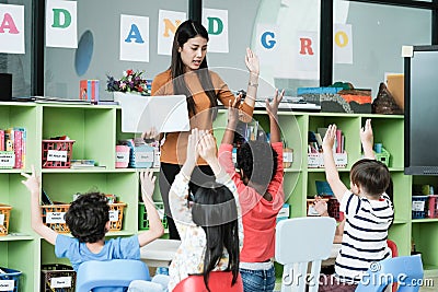 Young asian woman teacher teaching kids in kindergarten classroom, preschool education concept Stock Photo