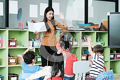 Young asian woman teacher teaching kids in kindergarten classroom, preschool education concept Stock Photo