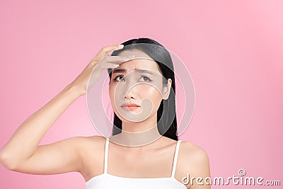 Young Asian woman touch and worry about her face. Acne, pimple, clear and clean, oily, dry skin concept Stock Photo