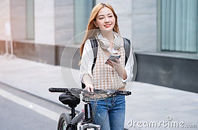 Young Asian woman using bicycle as a means of transportation Stock Photo