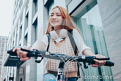 Young Asian woman using bicycle as a means of transportation Stock Photo