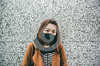 Young asian woman wearing a black mouth mask as her suffers from severe air pollution. Stock Photo