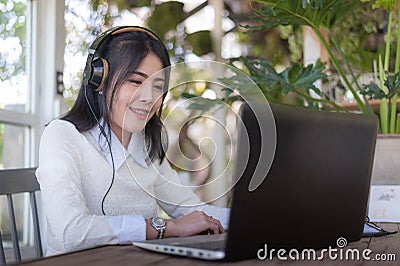 Young Asian woman working with laptop in coffee shop Stock Photo