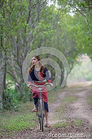 Young asian women rideing an old bike in field. Stock Photo