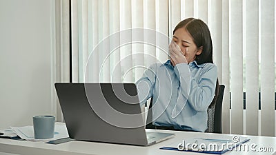 Young asian women yawning in the afternoon of working at the office Stock Photo