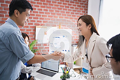 Young Asians shake hands for business partners in the office Stock Photo