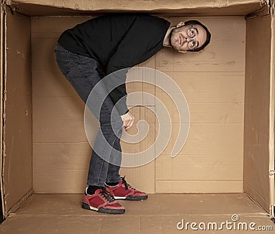 Young aspiring employee trying to enlarge his office space Stock Photo