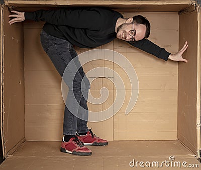 Young aspiring employee trying to enlarge his office space Stock Photo