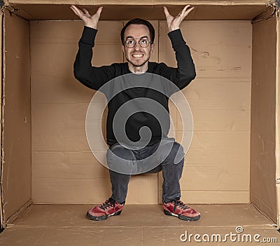 Young aspiring employee trying to enlarge his office space Stock Photo