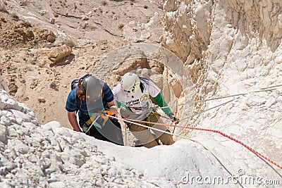 Young athletes start pair downhill using snapping gear in the mountains of the Judean Desert near the Tamarim stream near Editorial Stock Photo