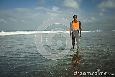 Young athletic and attractive african american sport man posing relaxed outdoors at the beach after fitness workout standing cool Stock Photo