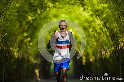 Young athletic and attractive black afro American runner man doing running workout training outdoors on urban city park in fitness Stock Photo