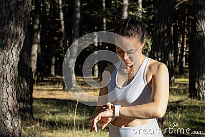 Young athletic girl looking at the stopwatch timer for her training session Stock Photo