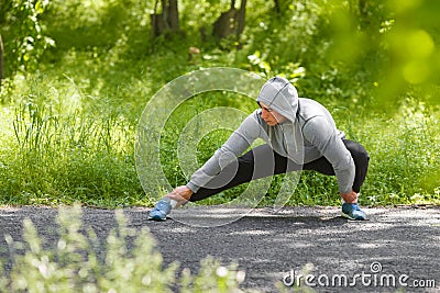 Young athletic man doing stretching exercises, outdoor. Healthy man working out in park Stock Photo