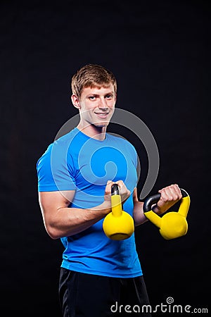 Young athletic man standing with kettlebells on Stock Photo