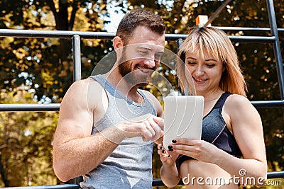 Young athletic woman and bearded man browsing the internet on ta Stock Photo