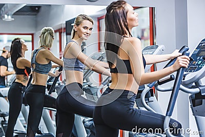 young athletic women working out on elliptical machines Stock Photo
