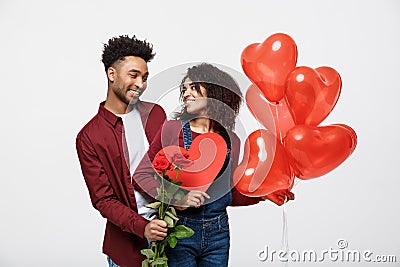 Young attractive african american couple on dating with red rose,heart and balloon. Stock Photo