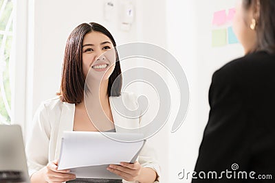 A young attractive asian woman is interviewing for a job. Her interviewers are diverse. Stock Photo