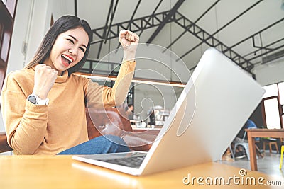 Young attractive asian woman looking at laptop computer feeling happy cheerful or excited expression success or win Stock Photo