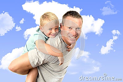 Young attractive and athletic father carrying on his back young beautiful and blond son having fun together posing isolated on blu Stock Photo