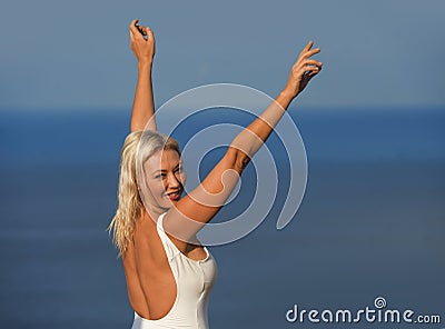 Young attractive and beautiful 30s blond hair woman in casual top and denim shorts spreading arms happy and cheerful posing Stock Photo