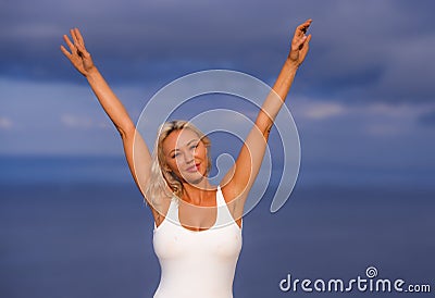 Young attractive and beautiful 30s blond hair woman in casual top and denim shorts spreading arms happy and cheerful posing Stock Photo