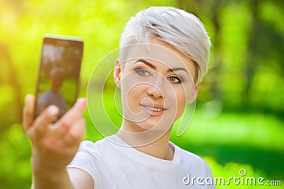 Young, attractive blond girl with short hair doing selfie Stock Photo