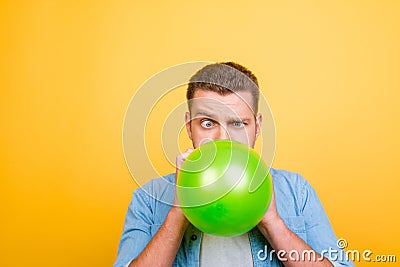 Young attractive blond man tired to blow up balloons new year pa Stock Photo