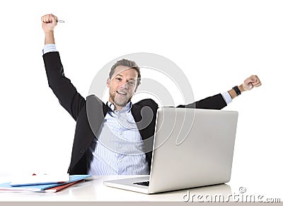 Young attractive businessman happy and hectic at office work sitting at computer desk satisfied celebrating Stock Photo