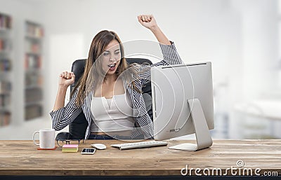 Young attractive businesswoman expressing success at office Stock Photo