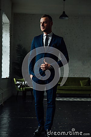 Young attractive and confident businessman in blue suit and black tie. Stock Photo