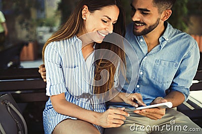 Young attractive couple on date sitting on bench Stock Photo