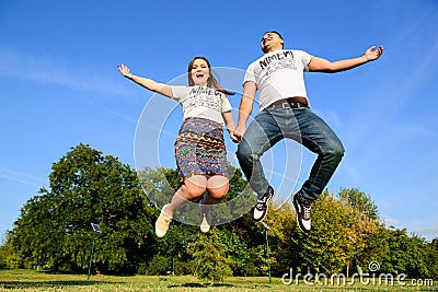 Jumping couple. Fun day outdoor Editorial Stock Photo