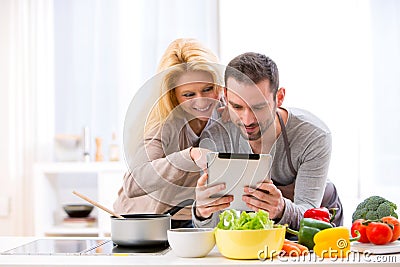 Young attractive couple reading recipe on a tablet Stock Photo