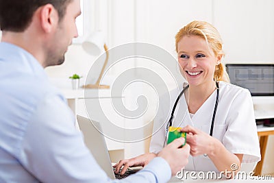 Young attractive doctor taking health insurance card Stock Photo