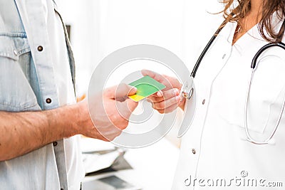 Young attractive doctor taking health insurance card Stock Photo