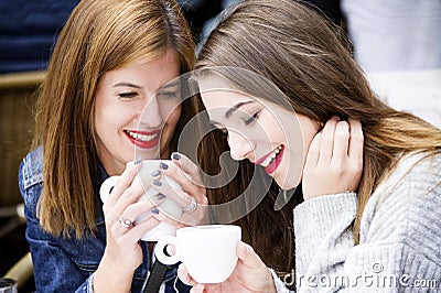 Young and attractive fashionable women are having fun at a cafe. Stock Photo