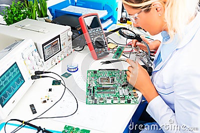 Female electronic engineer checking circuit board in laboratory Stock Photo