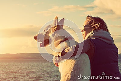 Young attractive girl with her pet dog at a beach Stock Photo