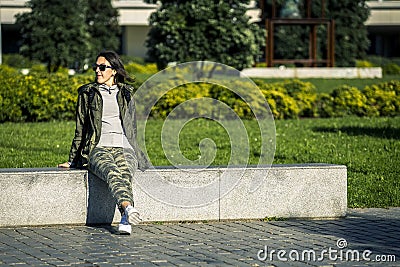 Young and attractive girl is sitting on bench. Stock Photo