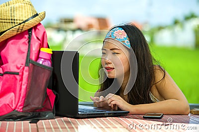 Young attractive and happy Asian Korean digital nomad working outdoors relaxed with laptop computer at tropical cafe as backpacker Stock Photo
