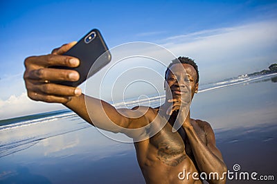 Young attractive and happy black African American sport man with athletic body and sixpack taking selfie photo with mobile phone Stock Photo