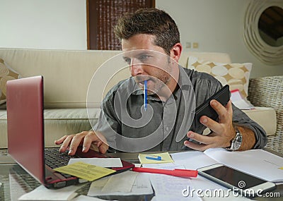 Young attractive and happy freelance business man with calculator and laptop doing domestic accounting paperwork of domestic Stock Photo