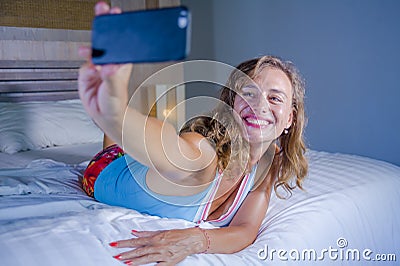 Young attractive and happy girl smiling cheerful and relaxed using internet social media app on mobile phone taking selfie photo p Stock Photo