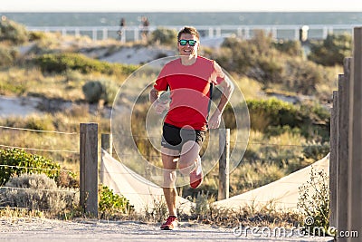 Young attractive and happy sport runner man with fit and strong healthy body training on off road track in Summer running workout Stock Photo