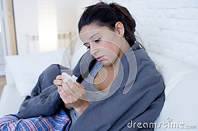 Young attractive hispanic woman lying sick at home couch in cold and flu in gripe disease symptom Stock Photo