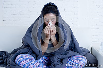 Young attractive hispanic woman lying sick at home couch in cold and flu in gripe disease symptom Stock Photo