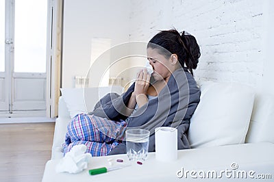 Young attractive hispanic woman lying sick at home couch in cold and flu in gripe disease symptom Stock Photo